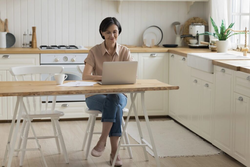 woman sitting in kitchen having virtual consultation
